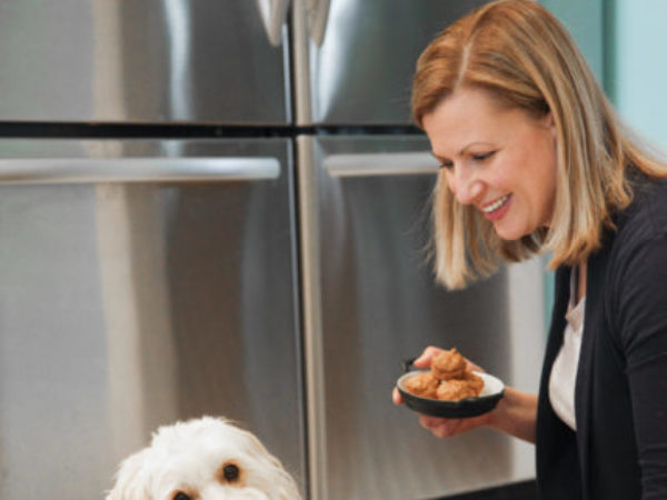 Anna Olson with dog giving paw and cupcakes