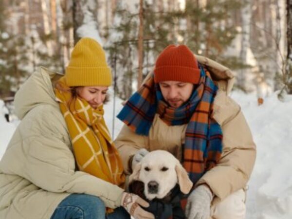 family in snow with dog