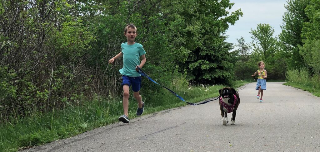 Kids running with dog on leash