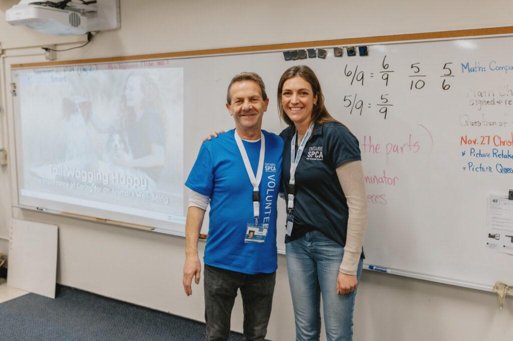 Ontario SPCA volunteer and staff member standing together in a classroom during a presentation on animal well-being