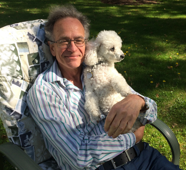 A man seated in a chair, enjoying the company of a dog.