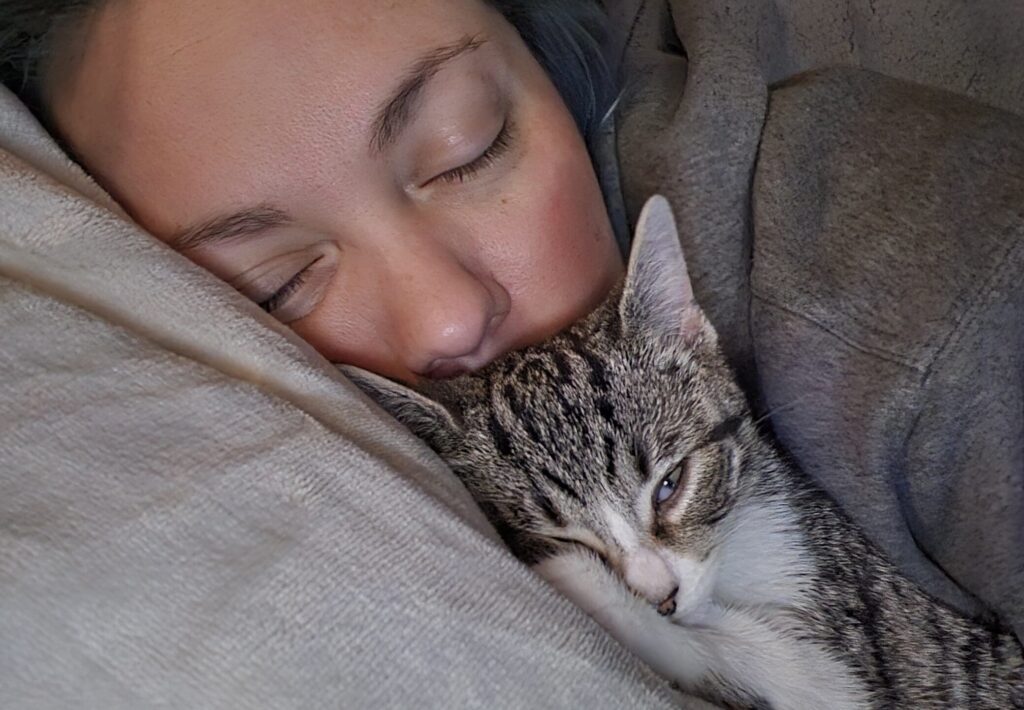 girl and kitten sleeping together
