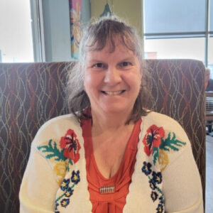 woman sitting in booth smilling at camera