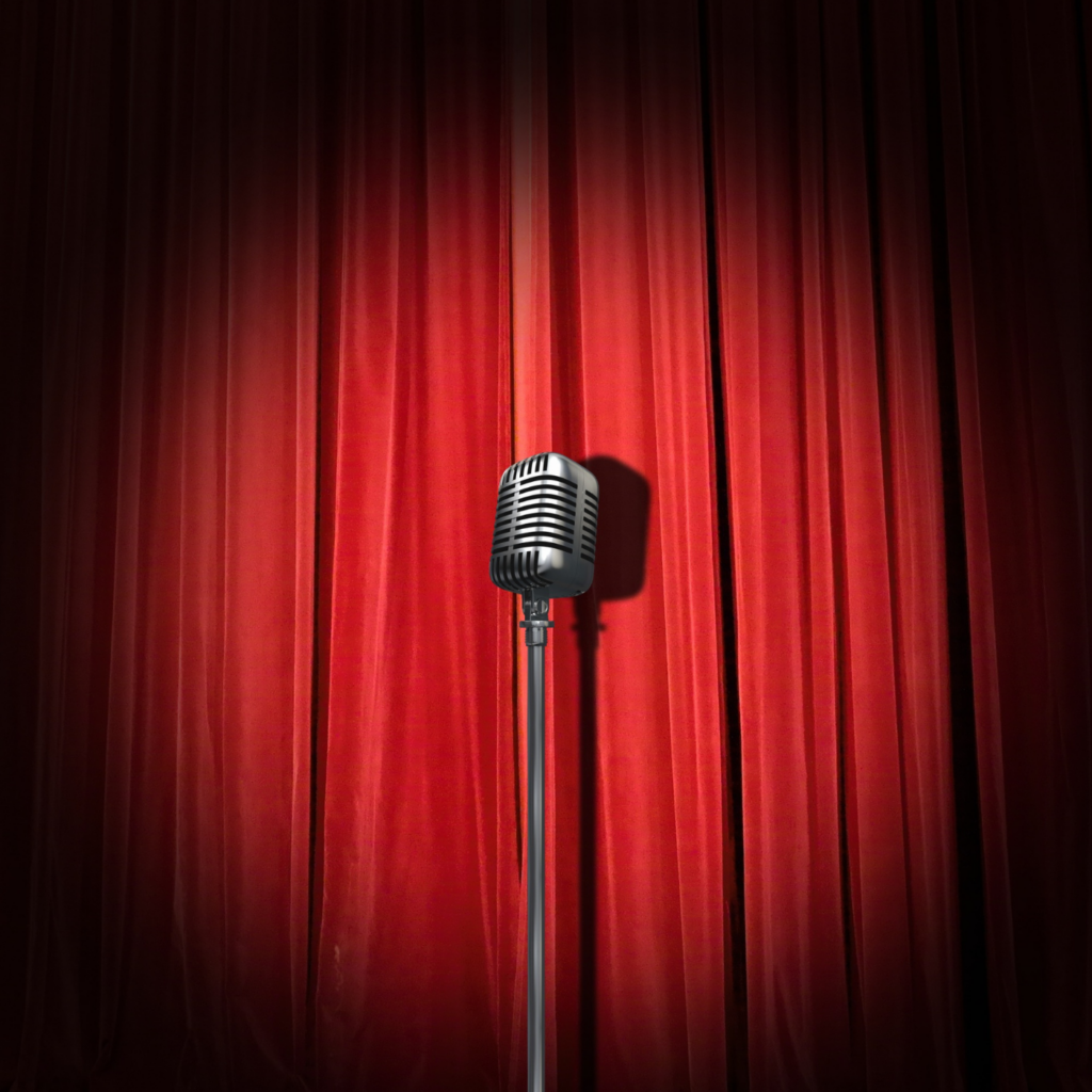 image of red velvet stage curtain with spotlight on microphone