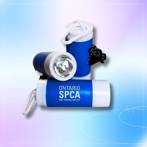 Ontario SPCA and Humane Society branded flashlight and waste bag dispenser set on a gradient background