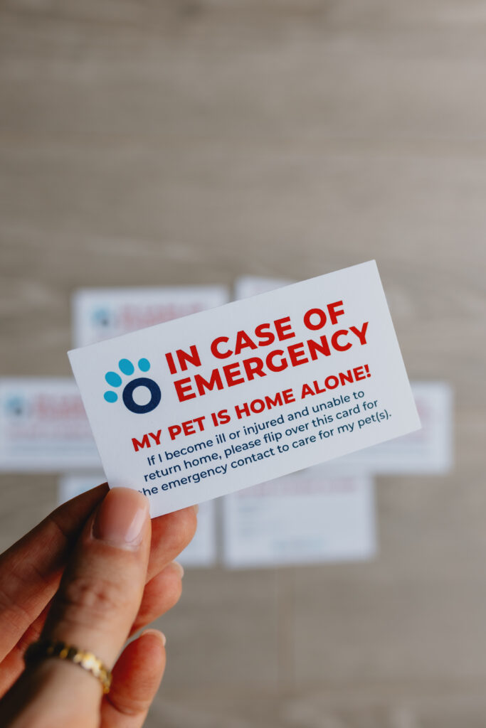 Hand holding an Ontario SPCA and Humane Society “In Case of Emergency My Pet Is Home Alone” wallet card