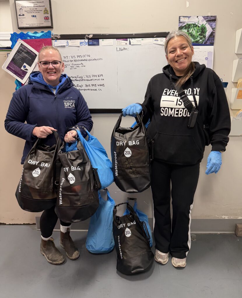 Two women holding black and blue bags