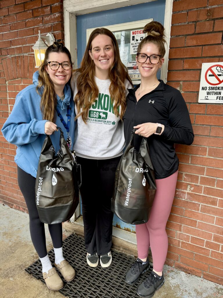Three girls holding bags