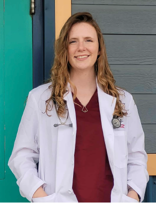 Girl in white lab coat smiling at camera