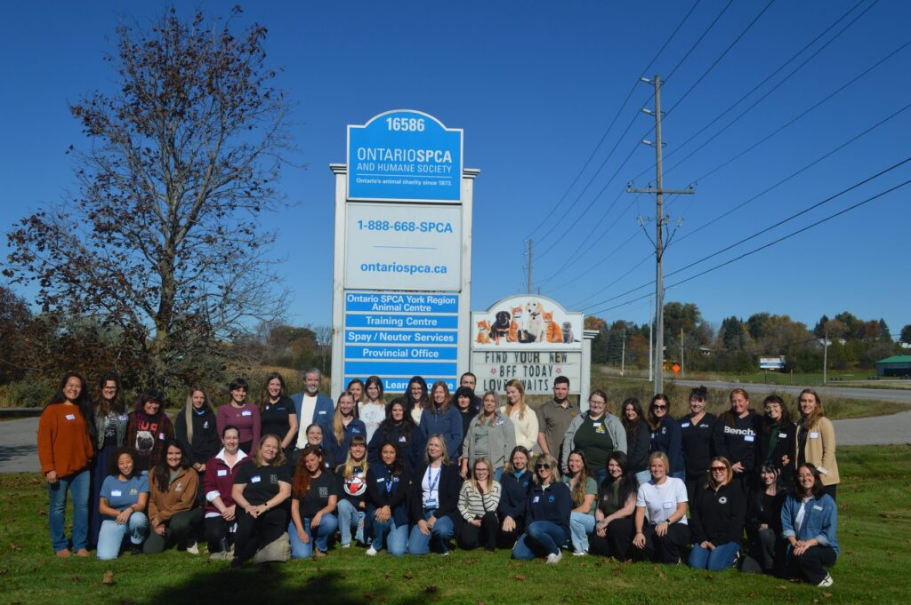 Workshop participants gather in front of the Ontario SPCA and Humane Society York Region Animal Centre sign